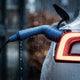 Rainwater beading on a blue charging connector locked into an electric car inlet