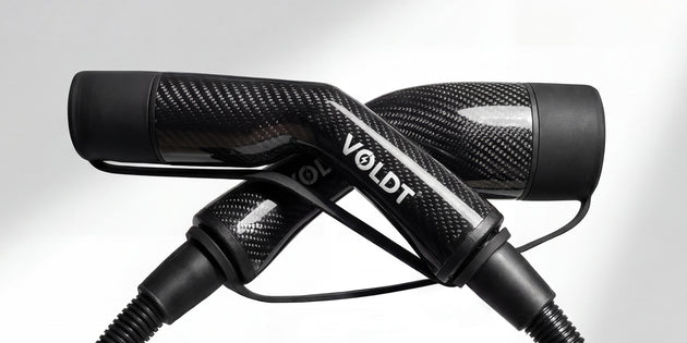 Studio shot of the black carbon fibre Voldt Type 2 EV charging cable and its connectors